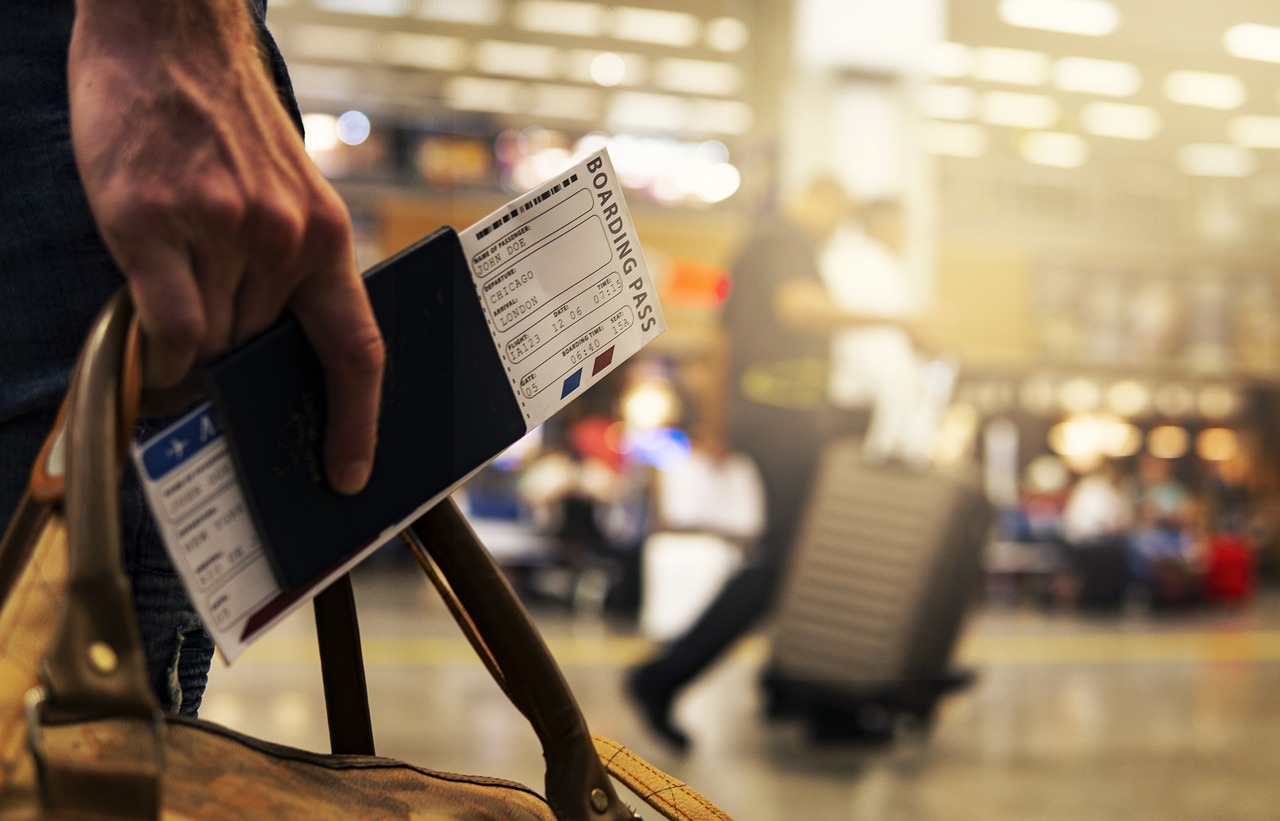 A man holding a boarding pass at the airport.