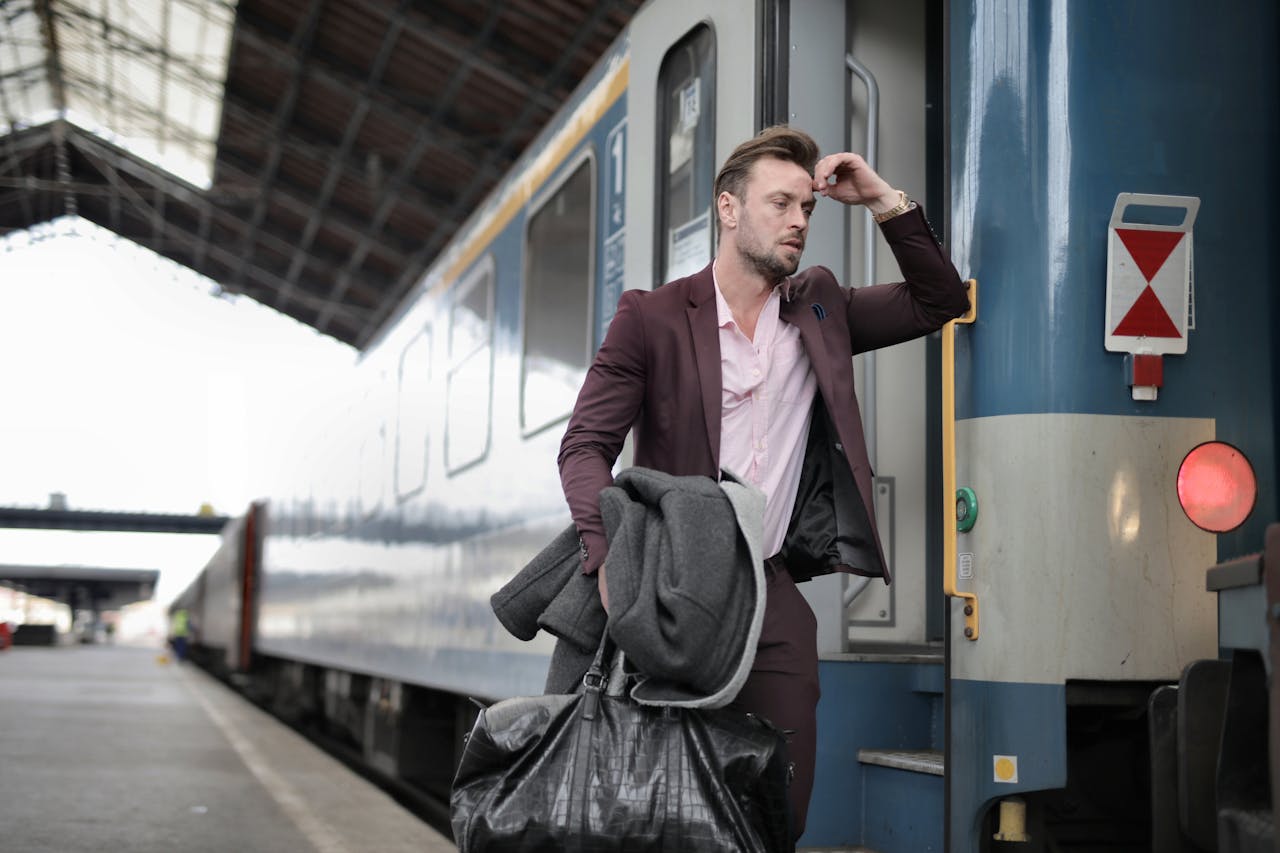 A businessman standing in front of the train; a supporting visual for the article discussing how to avoid burnout during frequent business trips.