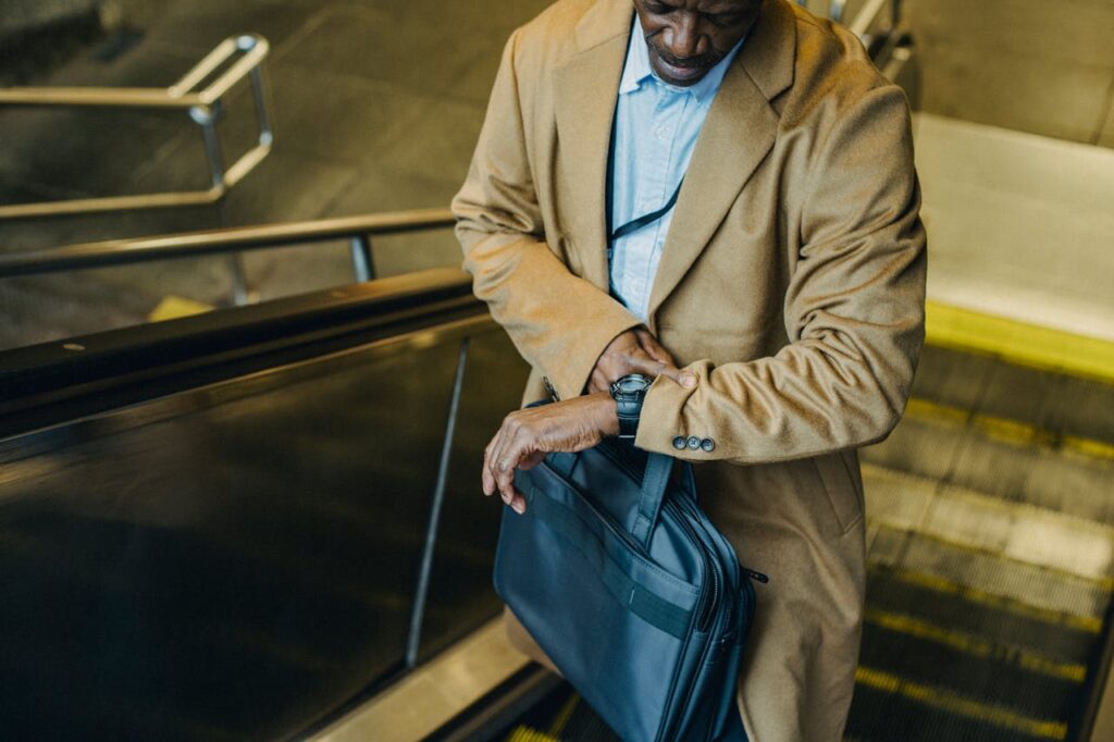 Man checking the time while on an escalator at an airport