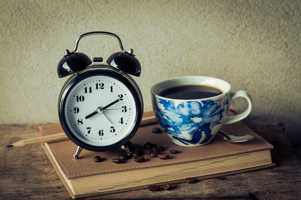 an alarm clock and a cup of coffee