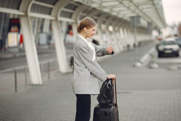 a woman waiting for transportation and looking at her watch